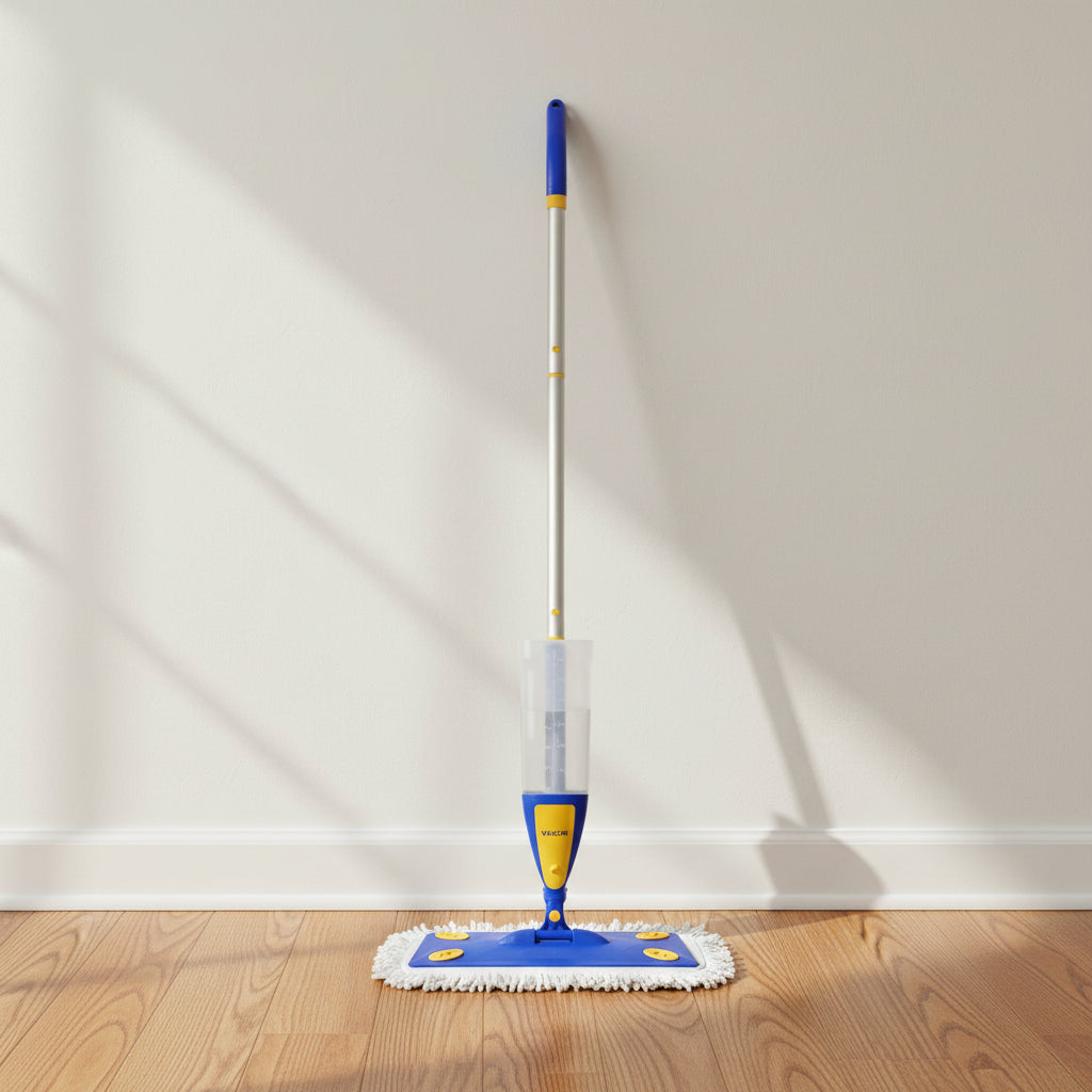 Spray mop with telescoping aluminum pole standing against wall on oak hardwood hallway floor