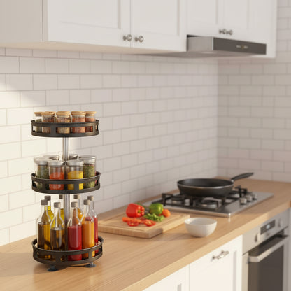 A three-tier rotating spice rack organizer on a wooden table, set against a white subway tile wall. The rack features a dark metal frame holding glass jars and bottles, with some spice containers on the top shelf.
